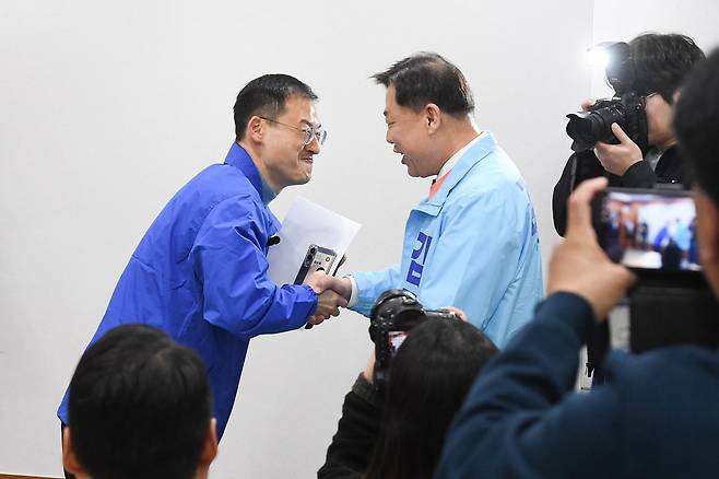 25일 울산시의회 프레스센터에서 김상욱 민주당 의원(왼쪽)과 김종훈 전 동구청장(진보당)이 우연히 만나 악수하고 있다. 6ㆍ3 지방선거에서 울산시장 후보로 출마하는 이들은 범진보 진영 후보 단일화 작업을 진행할 것으로 예상된다. 연합뉴스