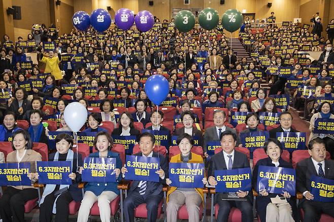 정청래 더불어민주당 대표(앞줄 왼쪽 네 번째)와 이수진 여성위원회 위원장(앞줄 왼쪽 세 번째)을 비롯한 의원들과 지방 선거 출마 예정자, 현역 기초단체장 및 지방 의원, 여성 당원들이 지난 2월 국회 의원회관에서 열린 2026 지방선거 승리 여성 결의대회에서 ‘지선 승리와, 여성 공천 30%’ 구호를 외치고 있다. [연합뉴스]