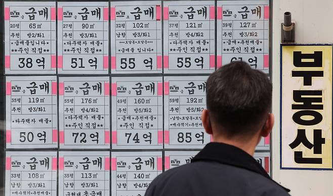 한 시민이 서울 강남구 부동산 중개업소에 붙은 급매물 안내문을 읽고 있다. 연합뉴스
