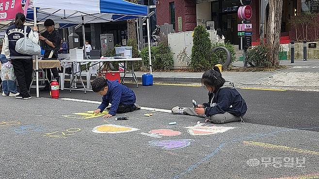 광주 동구 금남로와 충장로 일대에서 열린 ‘걷자잉’에 참여한 아이들이 길거리에 그림을 그리고 있다. 김종찬기자 jck41511@mdilbo.co