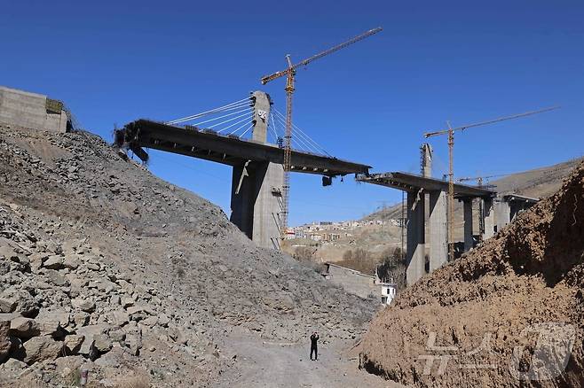 3일(현지시간) 이란 카라즈에서 한 남성이 미국의 공습으로 파괴된 B1 교량을 촬영하고 있다. 튀르키예 아나돌루 통신에 따르면 이란 반(半)관영 파르스통신은 도널드 트럼프 미국 대통령이 B1 교량 파괴 영상을 공개한 직후인 2일 "역내 국가들의 주요 교량 여러 곳이 표적이 될 수 있다＂며 목록을 공개했다. 2026.04.03. ⓒ AFP=뉴스1