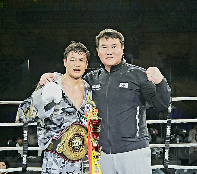 세계복싱협회 라이트급 아시아 챔피언 최시로가 2026년 4월 경기도 남양주체육문화센터 특설 링에서 타이틀 2차 방어 성공 기념 촬영을 하고 있다. 오른쪽은 FW1 최완일 대표. 사진=한국복싱커미션 KBM