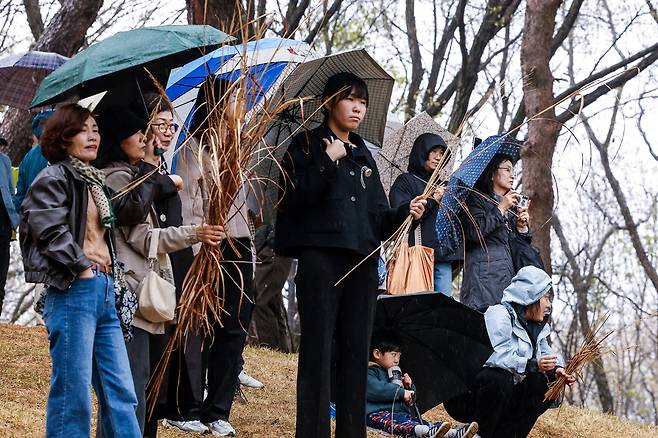 절기상 한식(寒食)인 6일 경기 구리시 동구릉 내 태조 이성계의 건원릉(健元陵)에서 시민들이 봉분에 있던 억새를 손에 쥐고 있다.