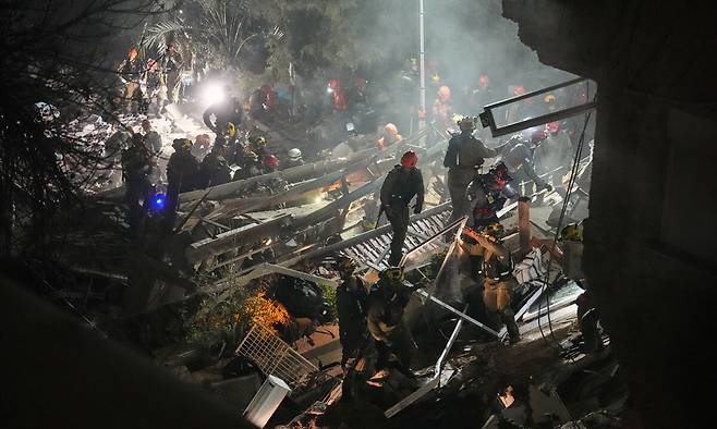 5일 레바논 수도 베이루트 남쪽 인구 밀집 지역이 이스라엘의 공습을 받아 콘크리트가 부서지고 철골 구조물이 드러난 가운데 구조대원들이 희생자들을 수색하고 있는 모습. AP연합뉴스