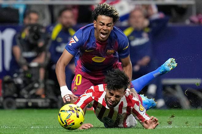 바르셀로나 공격수 라민 야말(위)이 5일(현지시간) 스페인 마드리드에서 열린 라리가 경기에서 아틀레티코 마드리드 수비수 니코 곤살레스의 태클을 받으며 넘어지고 있다. 이 반칙으로 곤살레스는 경고 누적으로 퇴장당했다. AP
