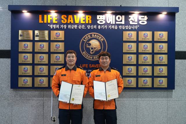 지난달 30일 부산소방재난본부에서 열린 ‘라이프세이버’ 수여식에서 허정필(오른쪽) 소방위와 이상환 소방장이 인증서와 배지를 전달받고 있다. 뒤쪽엔 ‘명예의 전당’ 명패. 부산소방본부 제공