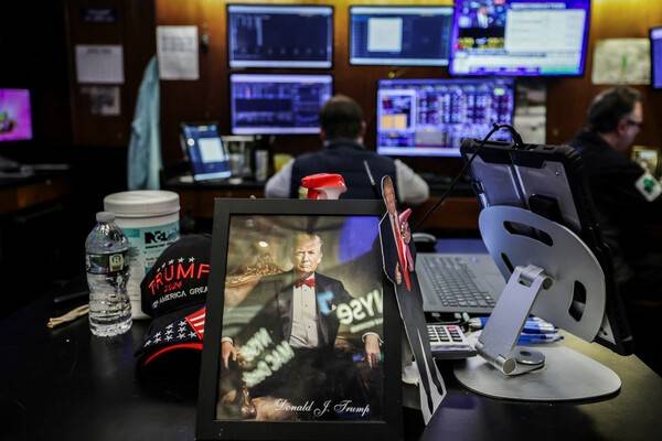 2026년 4월 2일, 미국 뉴욕시의 뉴욕증권거래소(NYSE)에서 거래자들이 업무를 보는 동안 책상 위에 도널드 트럼프 미국 대통령의 사진이 놓여 있다. [출처=연합뉴스]