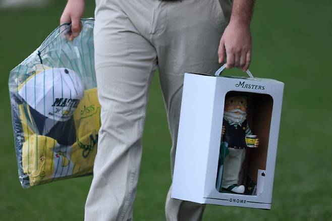한 팬이 마스터스 기념품 중 최고 인기 품목인 목각인형(놈)을 손에 들고 이동하고 있다. (사진=AFPBBNews)