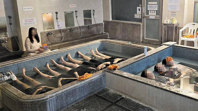 부산의 한 목욕탕에서 ‘명상 프로그램’이 열렸다. 참가자들이 온탕에 나란히 누워 음악을 들으며 쉬고 있다. 요즘 공중목욕탕에서 함께 목욕하며 스트레스를 푸는 20·30대가 늘고 있다. 동호회도 유행하고 있다. /독자 제공