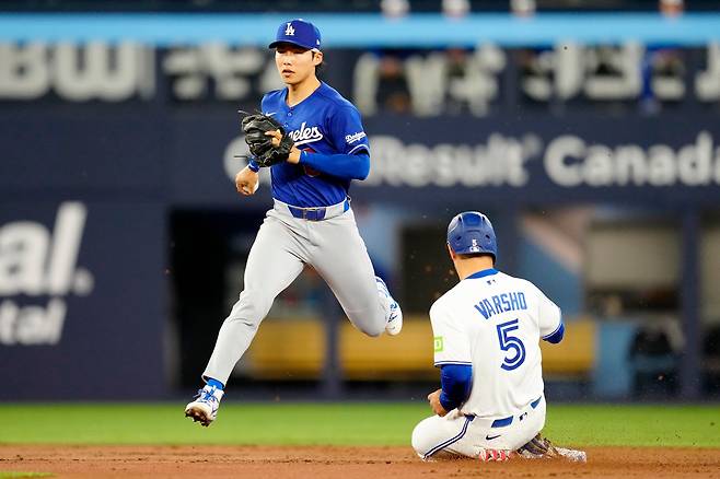 <YONHAP PHOTO-1959> Los Angeles Dodgers' Hyeseong Kim, left, forces out Toronto Blue Jays' Daulton Varsho (5) to end the first inning of a baseball game in Toronto, Monday, April 6, 2026. (Frank Gunn/The Canadian Press via AP) MANDATORY CREDIT/2026-04-07 08:41:43/<저작권자 ⓒ 1980-2026 ㈜연합뉴스. 무단 전재 재배포 금지, AI 학습 및 활용 금지>