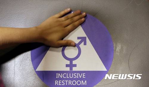 【시애틀=AP/뉴시스】  버락 오바마 미국 대통령이 2016년 5월 행정 지침에 따라서 성전환 학생들의 현재 성에 따른  시설 사용이 허가된 후  시애틀시의 네이선 헤일 고교의 화장실에서  성적 소수자도 함께 쓴다는  보호 스티커가 부착되고 있다.  도널드 트럼프 정부는 다음해 이를 폐기했고 바이든정부가 재허용한 것을 2016년 4월에 다시  폐기했다. 2026. 04. 07.