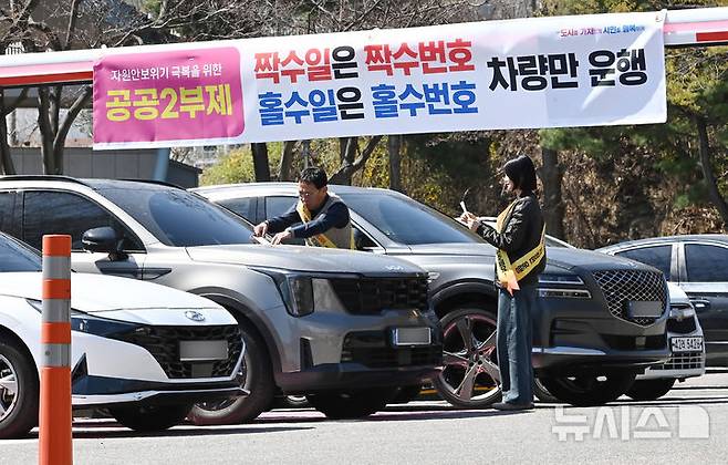 [군포=뉴시스] 김종택기자 = 공공기관 차량 2부제 시행을 하루 앞둔 7일 경기 군포시청 주차장에서 직원들이 안내문을 차량에 부착하고 있다. 2026.04.07. jtk@newsis.com