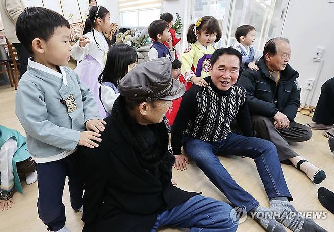 아이들에게 안마 받는 어르신 [연합뉴스 자료사진]