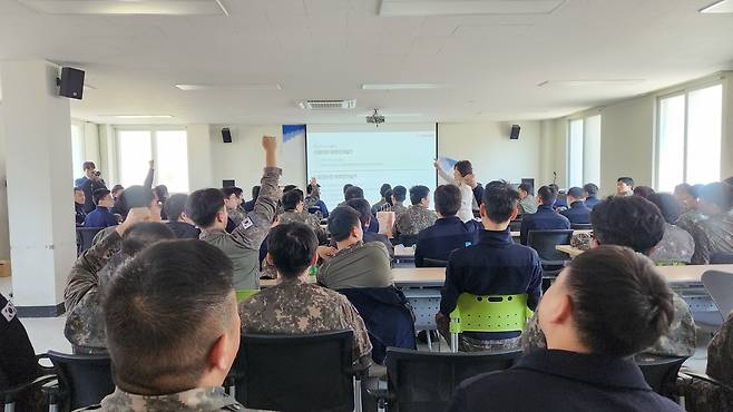 지난 7일 경기 화성시 남양지역의 한 공군부대에서 김은경 신용회복위원장이 공군을 대상으로 신용관리 교육을 진행하고 있다. 강연에 참석한 군인들이 퀴즈를 맞히기 위해 손을 들고 발표하는 모습. [정호원 기자]