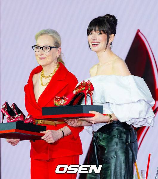 [OSEN=민경훈 기자] 8일 오전 서울 종로구 포시즌스 호텔 서울에서 영화 '악마는 프라다를 입는다 2' 내한 기자간담회가 열렸다.'악마는 프라다를 입는다 2'는 전설적인 패션 매거진 '런웨이'의 편집장 미란다(메릴 스트립 분)와 20년 만에 기획 에디터로 돌아온 앤디(앤 해서웨이 분)가 럭셔리 브랜드의 임원이 된 에밀리(에밀리 블런트 분)와 재회하고, 완전히 달라진 미디어 환경 속에서 다시 한번 패션계의 주도권을 잡기 위해 모든 커리어를 거는 이야기다. 오는 29일 전 세계 최초 개봉.배우 메릴 스트립, 앤 해서웨이가 기자간담회에서 꽃신 스타일의 하이힐 선물을 받고 감동하고 있다. 2026.04.08/rumi@osen.co.kr