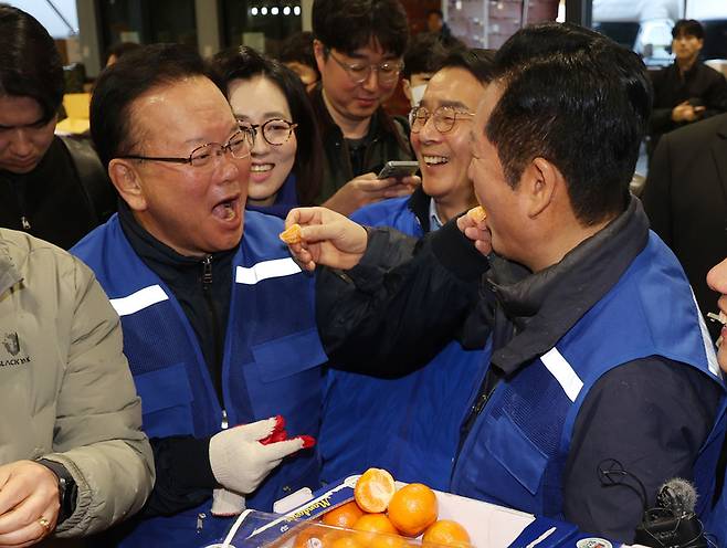 정청래 더불어민주당 대표와 민주당의 대구시장 후보로 확정된 김부겸 전 총리가 8일 오전 대구 북구 매천동 농수산물도매시장을 찾아 민생현장을 살피며 귤을 맛보고 있다. / 사진=연합뉴스