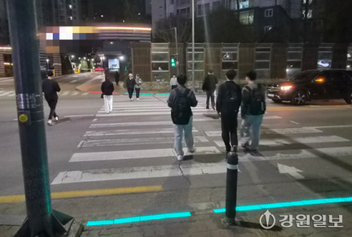 ◇8일 찾은 춘천시 후평동의 아파트단지 앞 사거리, 보행자들이 바닥형 신호등을 확인한 후 횡단보도를 건너고 있는 모습. 사진=고은기자