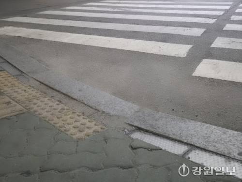 ◇춘천 후평사거리에 설치된 바닥형 신호등. 초록색 보행자 신호등이 들어왔지만 바닥신호등은 꺼진 상태다. 신호등 일부는 흙속에 파묻혀 있다. 사진=고은기자