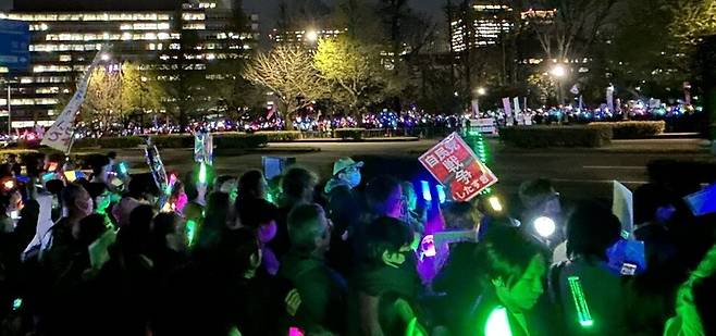 지난 8일 일본 지요다구 국회의사당 앞에서 열린 ‘평화 헌법을 지키기 위한 긴급행동’에서 시민들이 응원봉을 들고 집회에 참여하고 있다.