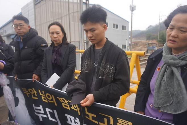 뚜안의 동생 응웬 반 뚜(오른쪽 둘째)가 10일 형이 일했던 경기 이천시 호법면 자갈 가공 업체 앞에서 형이 사용했던 모자와 팔찌를 쥐고 있다. 이준희 기자