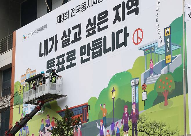 지난 4월 9일 경기도 수원시 영통구 경기도선거관리위원회에서 관계자들이 투표 참여 홍보 현수막을 설치하고 있다. 연합뉴스
