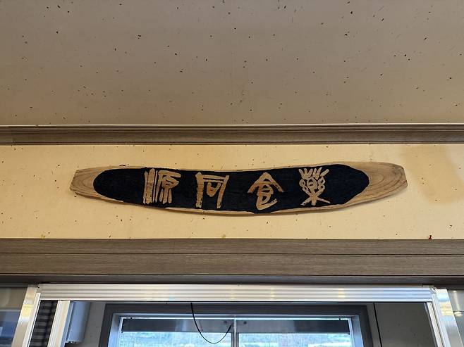 ‘맛있는 부엌’ 입구에 걸려 있는 약식동원(藥食同源) 현판. ‘약과 음식은 그 근원이 같다’는 뜻으로, 평소 좋은 음식을 먹는 것이 곧 병을 예방하고 치료하는 약이 된다는 의미다.