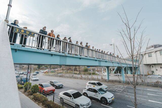 ‘리모트 서울’ 관객들이 육교 위에서 AI 음성의 지시에 따라 도로를 바라보고 있다. ⓒGS아트센터