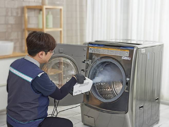롯데하이마트 안심케어 서비스 클리닝 기사가 세탁기를 관리하고 있다. (사진=롯데하이마트)