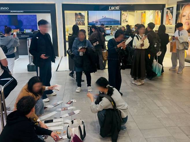 지난 8일 오후 서울 중구 한 시내 면세점 화장품 매장 앞에서 외국인 고객들이 여권과 영수증 등을 바닥에 펼쳐놓고 정리하고 있다. 이날 면세점은 해외 관광객들의 발길이 이어지며 붐비는 모습을 보였다. 박호수 기자