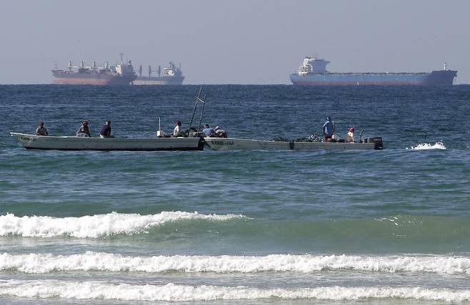 2012년 1월19일 호르무즈 해협 남쪽 아랍에미리트(UAE)의 라스 알 카이마 해안의 어선 뒤로 유조선 2척이 지나가고 있다. 미 해군이 4월 13일부터 호르무즈 봉쇄를 한다고 발표한 이후 미 국내 주가가 일제히 올랐다고 AP통신은 보도했다. 사진=뉴시스