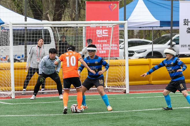 경기 중인 FC CNB 전맹축구클럽(파란색)과 화성시각축구단(주황색). 롯데장학재단 제공