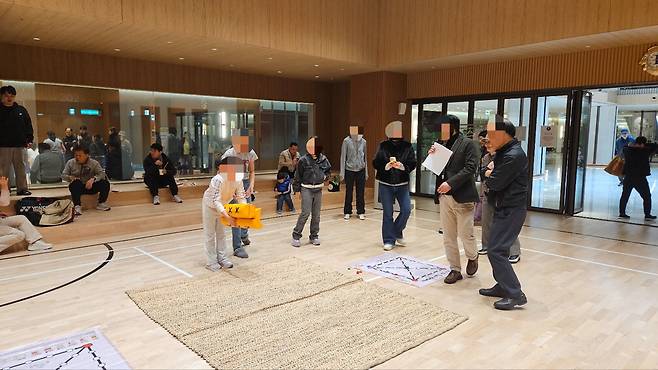백운호수 푸르지오 커뮤니티에서 입주민이 손주들과 윷놀이를 하고 있다.  엠디엠