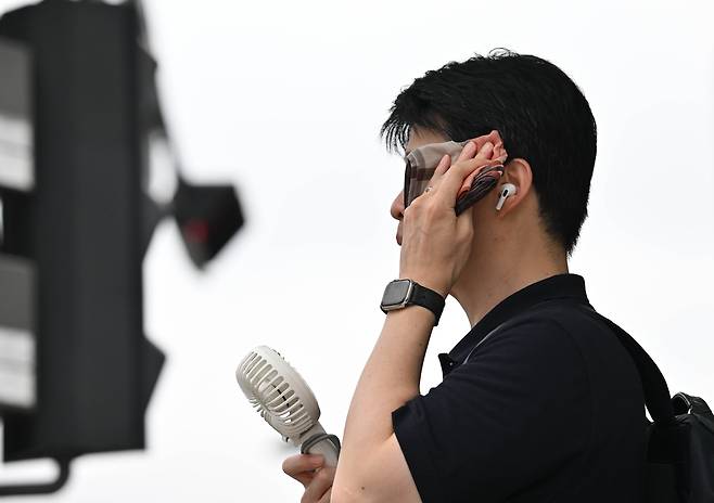 서울 종로구 세종대로 사거리에서 한 시민이 손풍기로 더위를 식히고 있다. 임세준 기자