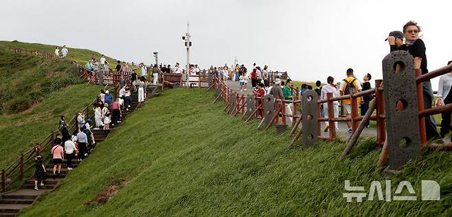 [서귀포=뉴시스] 우장호 기자 = 흐린 날씨를 보인 19일 오후 제주 서귀포시 성산일출봉에 외국인 관광객들이 찾아와 기암절경을 감상하고 있다. 2025.09.19. woo1223@newsis.com