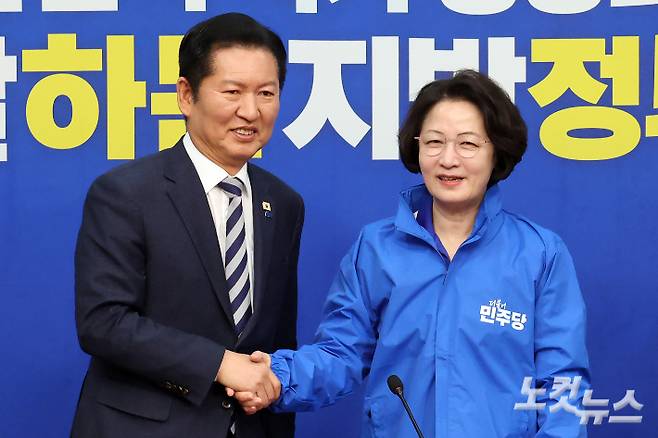 더불어민주당 정청래 대표가 13일 서울 여의도 국회에서 열린 경기지사 후보 환영식에서 추미애 후보에게 당 점퍼를 전달하고 악수를 하고 있다. 윤창원 기자