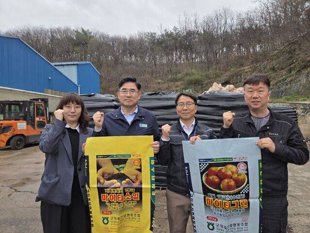 박배은 대구 군위축협 조합장(왼쪽 두번째)이 직원들과 자연순환농업센터에서 고품질 퇴비 포대를 들어보이고 있다.