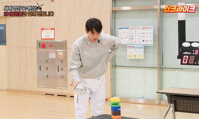 오상욱 선수가 펜싱 장비를 활용한 ‘젠가’ 미니게임에 집중하며 섬세한 컨트롤을 선보이고 있는 모습. SK텔레콤 제공