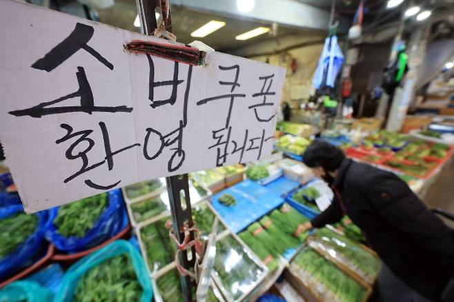 정부가 추가경정예산 편성으로 추진하는 ‘고유가 피해지원금’을 기초생활수급자 등 취약계층에게 오는 27일부터 우선 지급한다. 소득 하위 70%에게 소득과 지역에 따라 차등을 둬 10만~60만원을 지역화폐 형태로 준다. 사진은 12일 서울 동대문구 경동시장의 한 채소가게에 지난해 지급된 ‘소비쿠폰’ 안내문이 붙어 있는 모습. 뉴스1