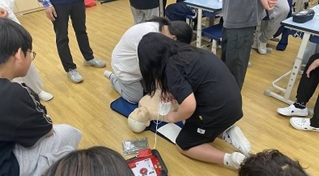지난해 9월 송파구 한 중학교에서 실시된 ‘학교로 찾아가는 구조 및 응급처치 교육’에서 학생들이 마네킹에 교육용 자동 심장 충격기를 사용해 보고 있다. 송파구 제공