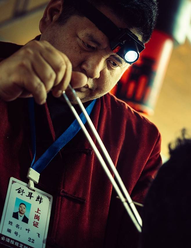 인민공원에서 만날 수 있는 귀파기 장인. 개인마다 고유의 번호가 있고 손에 든 쇠막대기를 진동시키며 호객을 한다