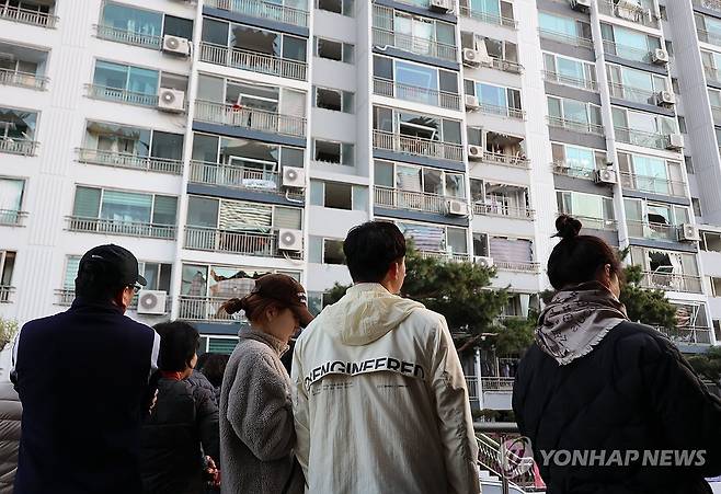 폭발 흔적 지켜보는 주민들 (청주=연합뉴스) 이성민 기자 = 13일 오전 청주시 흥덕구 봉명동의 한 아파트 주민들이 폭발 사고 여파로 깨진 창문을 바라보고 있다. 2026.4.13 chase_arete@yna.co.kr