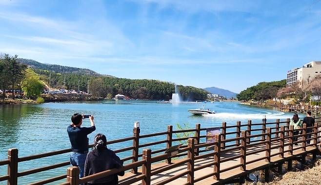 ▲ 지난 12일 오후 포천시 소흘읍 고모저수지를 찾은 시민들이 수변 데크길을 걸으며 봄기운을 만끽하고 있다. 탁 트인 호수 위로 가동 중인 분수와 모터보트가 현장의 활기를 더하고 있다. /이광덕 기자 kdlee@incheonilbo.com