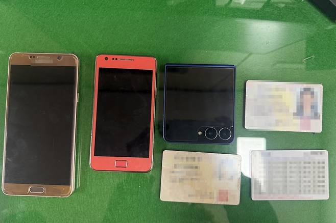 남의 신분증을 도용해 15년 동안 15억원이 넘는 돈을 가로챈 50대 여성이 경찰에 붙잡혔다 사진은 경찰이 압수한 휴대전화와 신분증.