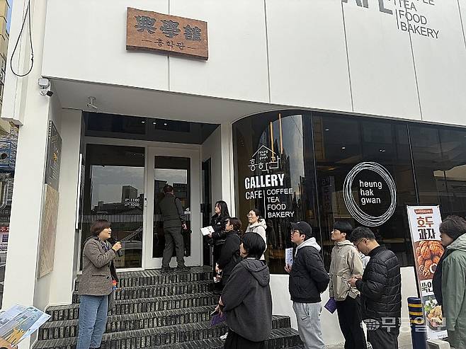 해설사들이 흥학관 옛 터 앞에서 흥학관의 역사에 대해 설명하고 있다.