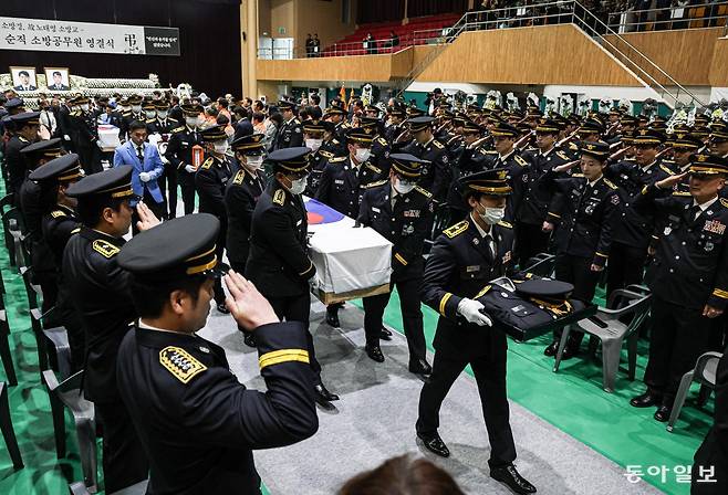 14일 오전 전남 완도군 농어민문화체육센터에서 고(故) 박승원 소방경과 고(故) 노태영 소방교의 영결식에서 이동하는 운구를 향해 소방관들이 거수경례하고 있다. 완도=이한결 기자 always@donga.com