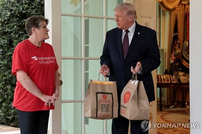 배달기사에게서 버거세트 받는 트럼프.  연합뉴스