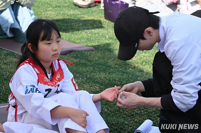 14일 서울 광화문광장에서 열린 ‘2026 광화문 멍때리기 대회’에서 관계자가 어린이 참가자의 심박수를 재고 있다.
