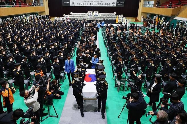 14일 오전 전남 완도군 농어민문화체육센터에서 열린 고 박승원 소방경·노태영 소방교의 영결식에서 소방관들이 운구하고 있다. 연합뉴스