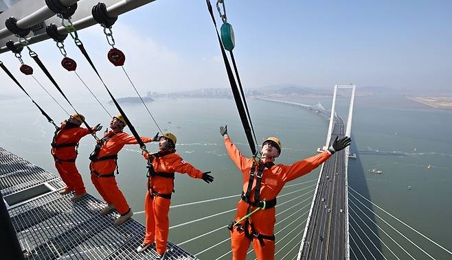 ▲&nbsp;세계 최고 높이 해상교량 전망대인 인천 청라하늘대교(제3연륙교) 전망대가 다음 달 개장을 앞둔 가운데 지난달 25일 시설 점검에서 관계자들이 안전장비를 착용하고 외부 공간을 걸으며 '엣지워크'를 시연하고 있다. /이재민 기자 leejm@incheonilbo.com