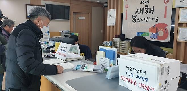 ▲ 청송지역 대표 결재수단으로 자리잡은 '청송사랑화폐'가 누적발행액 3200억 원을 넘어서 지역순환경제의 성공모델로 정착했다는 평가다. 사진은 청송지역 한 농협창구에서 청송사랑화폐를 구입하는 주민. 서충환 기자.